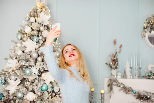 Happy blonde woman making selfie near fir tree — Stock Photo, Image