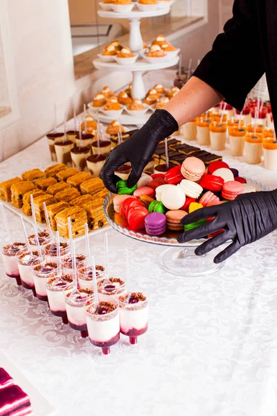 Catering bar per festeggiare. Macaroni colorati su un piatto. Dolci gustosi serviti in tavola — Foto Stock