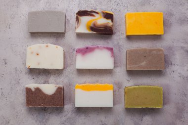 Flat lay composition with handmade soap bars on dark green background, top view