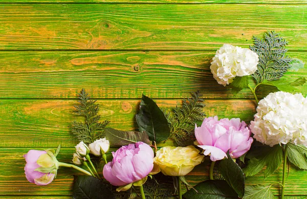 Hermosas flores tiernas de primavera y hojas sobre fondo de madera verde . — Foto de Stock