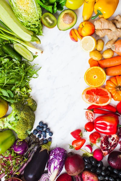 Szivárvány színű gyümölcsök és zöldségek egy fehér asztalon. Egészséges táplálkozás koncepciója — Stock Fotó