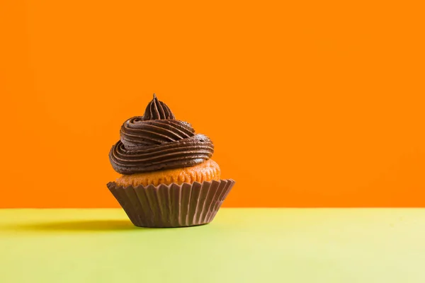 Schokoladen-Cupcake mit Sahnehäubchen auf gelbem Hintergrund — Stockfoto