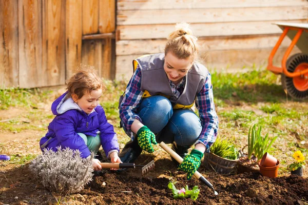 Vrolijke vrouw en meisje werken op een grond — Stockfoto