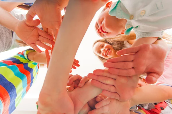 As crianças brincam juntas, juntam os braços — Fotografia de Stock