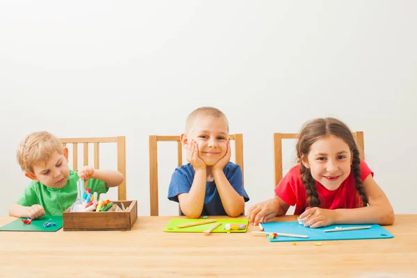 Tre bambini giocano con pasta colorata — Foto Stock