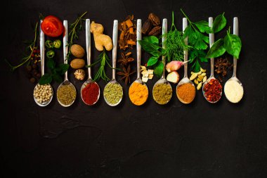 Siyah arkaplanda kaşıklar halinde baharat seti