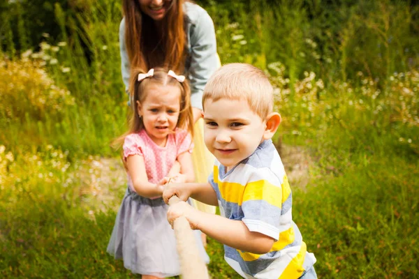 Junge Familie spielt Tauziehen mit der Natur — Stockfoto