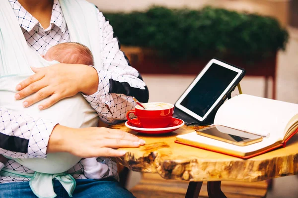 Yeni doğan bebekle dışarıda çalışan serbest çalışan biri. Bebek askıda uyurken tablet kullanan kadın — Stok fotoğraf