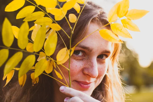 Feuille jaune sur la face femelle dans le parc — Photo