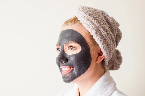 Piękna młoda kobieta używa czarnej maski twarzy — Zdjęcie stockowe