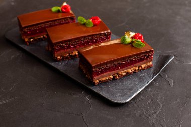 Siyah arka planda 3 parça çikolatalı pasta.