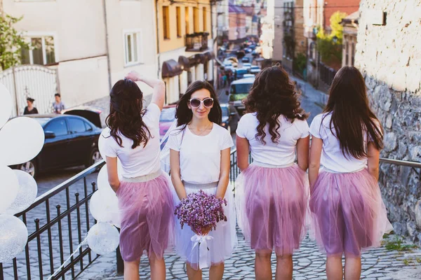 Mariée avec un bouquet tendre de fleurs de lilas s'amuser avec des copines en ville — Photo