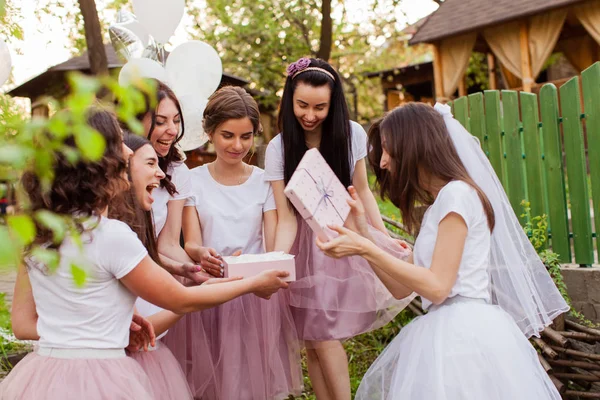 Hübsche Braut öffnet Geschenk von Freundinnen bei Junggesellenabschied — Stockfoto