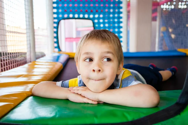 Petit garçon reposant sur le trampoline dans le centre de jeu — Photo