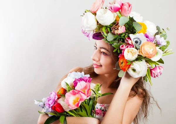 Hermosa joven modelo sonriente con flores brillantes en la cabeza —  Fotos de Stock