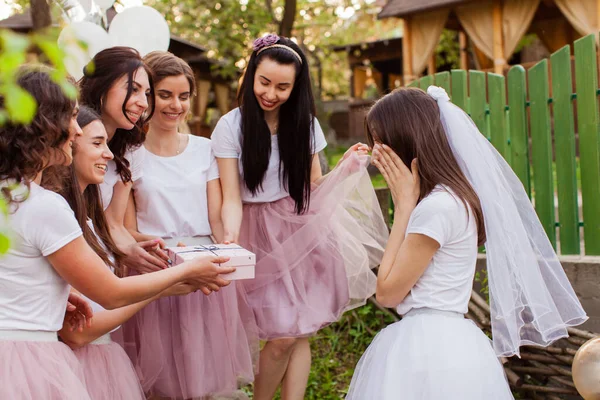 Happy girlfriends giving gift to bride at hen party — Stock Photo, Image