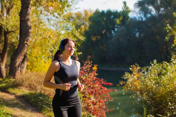 Kobieta jogging i słuchanie muzyki ze słuchawkami bezprzewodowymi — Zdjęcie stockowe