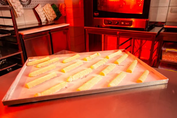 Bandeja para hornear con eclairs crudos lista para hornear . — Foto de Stock