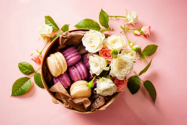 Коробка с вкусными яркими макаронами и цветами — стоковое фото