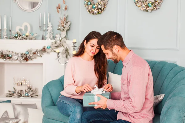 Schönes Paar auf einem Sofa, mit Geschenkbox — Stockfoto