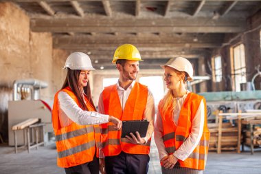 Güvenlik başlığı takan mühendisler iş planlama için görüşüyorlar.