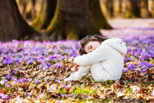 Lonely girl sitting on a ground in spring forest — Stock Photo, Image