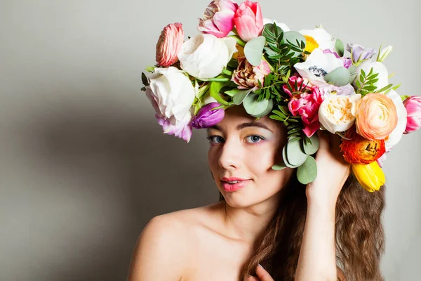 Piękna kobieta z długie kręcone włosy, idealny makijaż i wieniec wiosna kwiatów — Zdjęcie stockowe