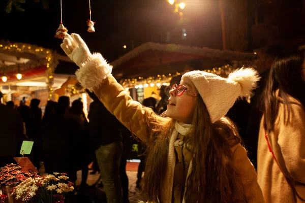 Pretty girl elige Chriastmas toy en la feria de Navidad mágica — Foto de Stock