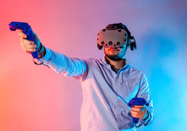 Fiatal férfi használja a virtuális valóság szemüveg és két gamepad — Stock Fotó