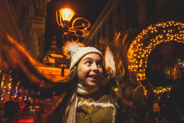 Chica feliz mira alrededor en el mercado de Navidad — Foto de Stock