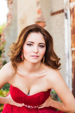 Lüks makyajlı, saç stili ve moda elbisesi olan zarif bir kadın.