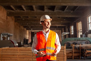 Beyaz şapkalı genç teknisyen fabrikada.