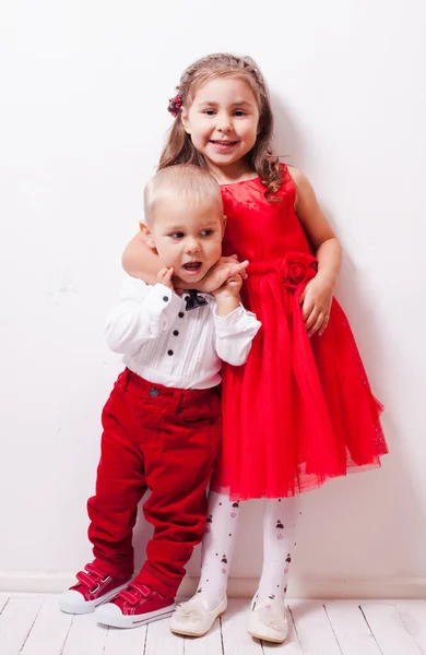 Liten pojke i röda byxor och en flicka i röd klänning — Stockfoto