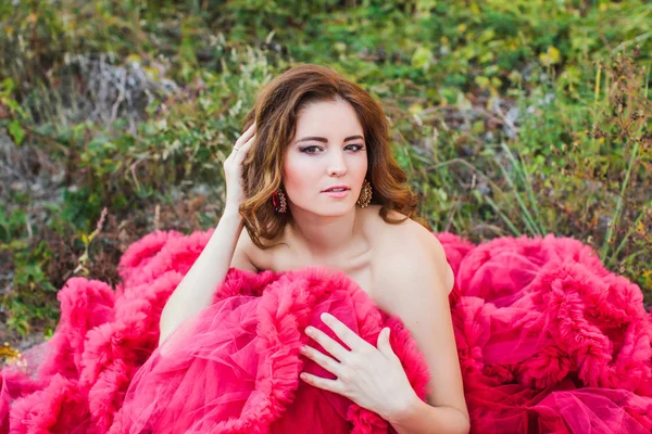 Sensual woman with fashion makeup, naked shoulders wears red fashionable fluffy dress — Stock Photo, Image