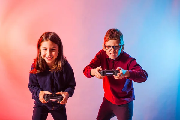 Excited kids with joysticks playing an interesting virtual game — Stock Photo, Image