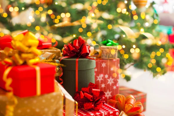 Рождественские подарки куча, огни на елке — стоковое фото