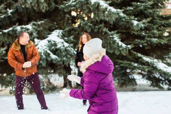 Gelukkige familie spelen sneeuwballen in winter park — Stockfoto