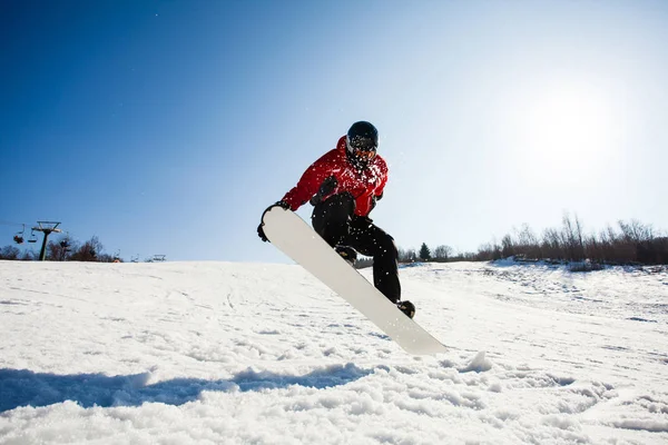Mężczyzna snowboarder w akcji skoki nad wzgórzem — Zdjęcie stockowe