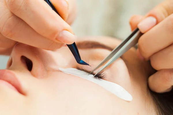 Estilista haciendo pestañas alargamiento para chica en un salón de belleza — Foto de Stock