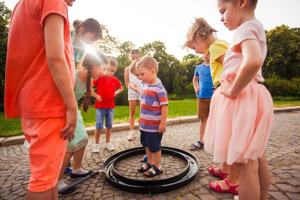 Niedlicher kleiner Junge steht in großer Seifenblase — Stockfoto