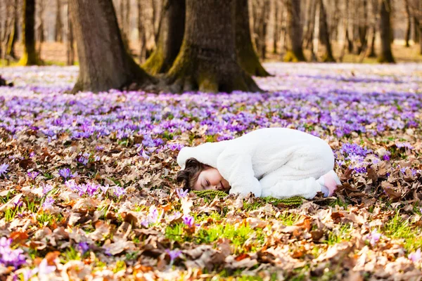 Портрет милой маленькой девочки среди первых весенних цветов — стоковое фото