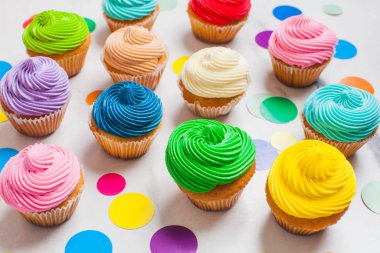 Colorful cupcakes on a white background with colorful dots
