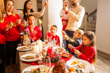 Kids and parents singing carols holding sparkles