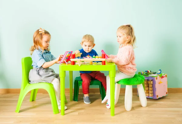 Bonito crianças brincando na sala de jardim de infância — Fotografia de Stock