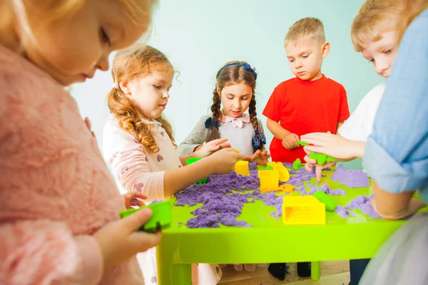 Happy kids having fun together and playing with kinetic sand — Stok fotoğraf