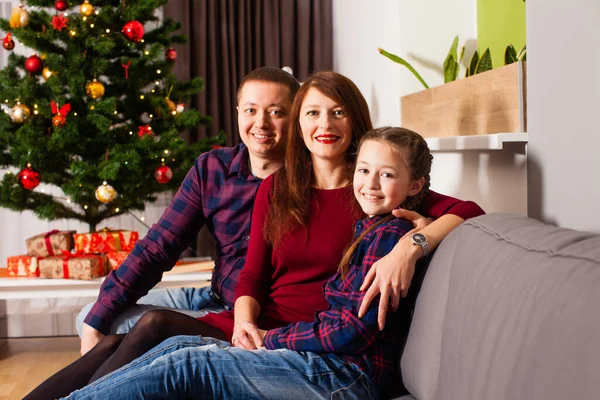 Happy family sitting on a couch at home — Stockfoto