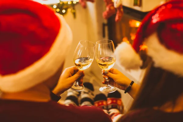 Back view Christmas couple near fireplace, toasting — ストック写真