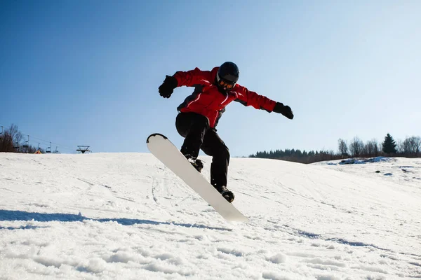 Hombre snowboarder en acción saltando colina —  Fotos de Stock
