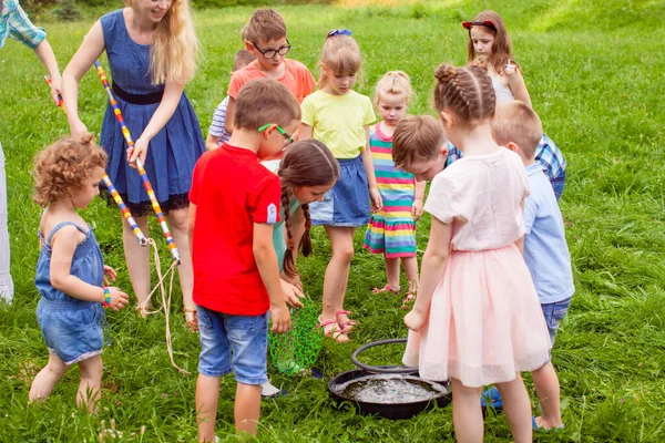 Children learning to make big soap bubbles outdoors — Stok fotoğraf
