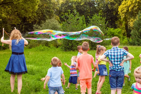 Kids birthday party at summer park with bubbles — Stock Photo, Image